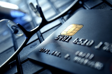 Black credit card and glasses on laptop