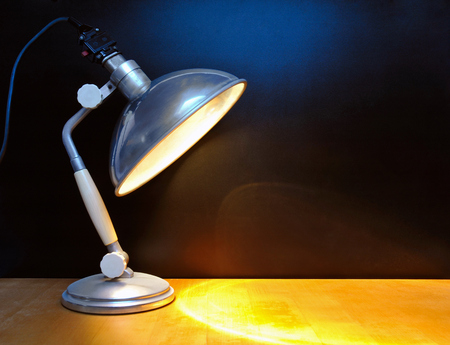 Vintage lamp in front of black wallの写真素材