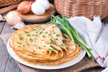 Pancakes with onions on a wooden background