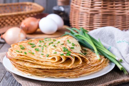 Pancakes with young green onions on a wooden backgroundの写真素材