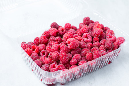 Fresh raspberries in plastic container