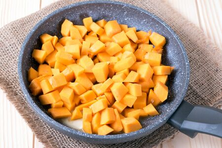 Cubes of pumpkin in a frying panの写真素材