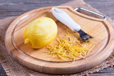 Cut lemon and zest on wooden board, closeupの写真素材