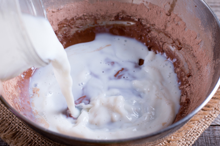 Mixing dough for pancakes or cake in bow on the tableの写真素材
