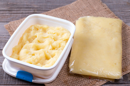 Mashed potatoes in a container and a bag