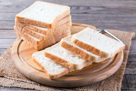 Bread for toast on a cutting board on a wooden table