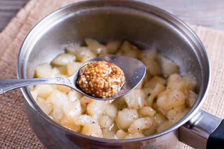 Preparation of pear confiture in a saucepan on a wooden backgroundの写真素材