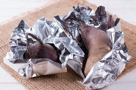Raw red beet prepared for baking in the oven. Red beetroot wrapped in aluminum foilの写真素材