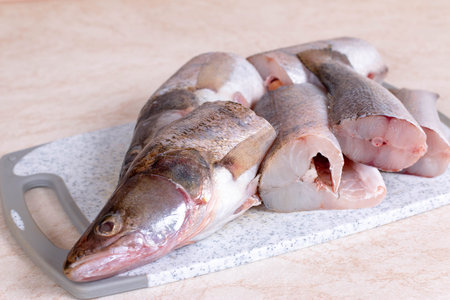 Fresh raw fish on a cutting board on the kitchen table