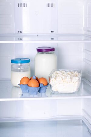 Eggs, milk and cottage cheese in the refrigerator, verticalの写真素材