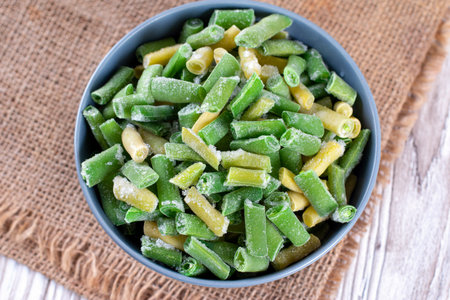Frozen Green Beans in bowl on wooden table