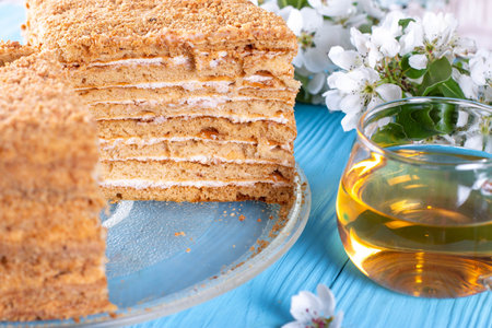 Homemade honey cake with sour cream on a blue wooden table