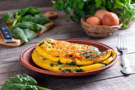 Omelet with spinach leaves. Omelette on plate, scrambled eggs