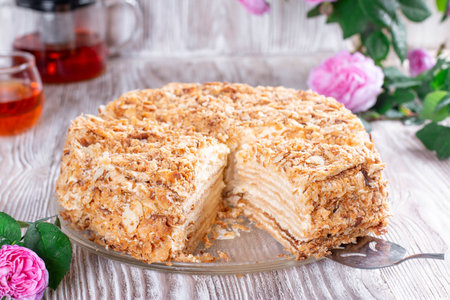 Classic Napoleon cake with a cup of tea. Traditional millefeuille dessert with puff pastry and custard, russian cuisine treatの写真素材