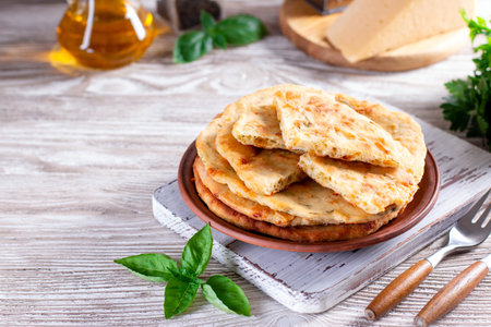 Baked dough tortilla with cheese in a ceramic plate on a wooden table. Place for text