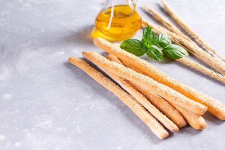 Italian grissini or salted bread sticks on a light stone background. Fresh italian snack.