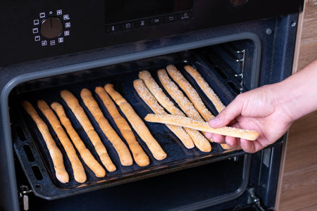 Freshly baked breadsticks in the oven. Italian grissini or salted bread sticks