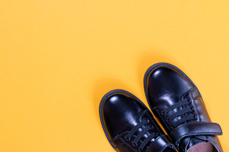 Black shoes and alarm clock on colored background. Flat lay, top view trendy background. Fashion...