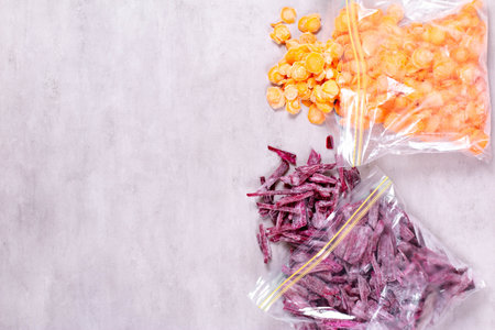 Frozen beet and carrot in reusable plastic bag on concrete backgroundの写真素材