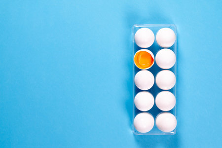 Top view, fresh chicken eggs isolated on a blue background. Natural healthy food and organic...