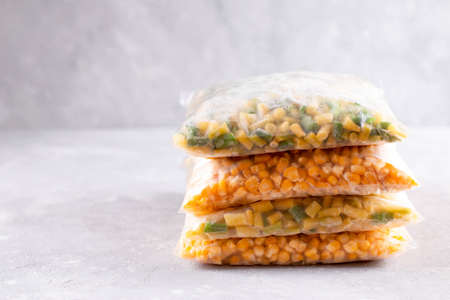 Assortment of frozen vegetables in a plastic bag on the table, copy spaceの写真素材