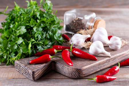 Chili peppers, garlic, herbs - Natural spices. Herbs and spices on a wooden board