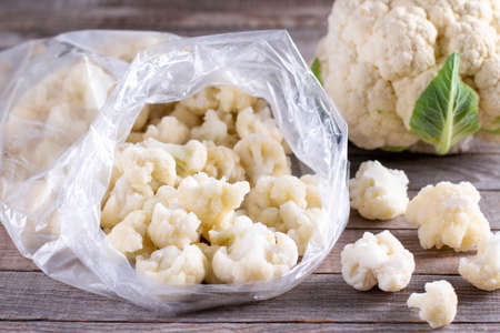 Frozen cauliflower florets on wooden table.の写真素材