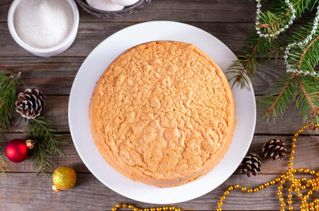 Sponge cake on a plate with Christmas tree branches, cones and toys. Top viewの写真素材
