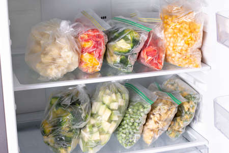 Plastic bags with different frozen vegetables in refrigerator. Horizontalの写真素材