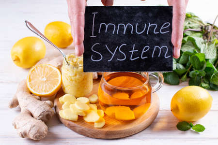 Immunity system improvement, food reach of vitamin?. Lemon, mint leaves, ginger and honey on a wooden table. Antiviral treatment.の写真素材