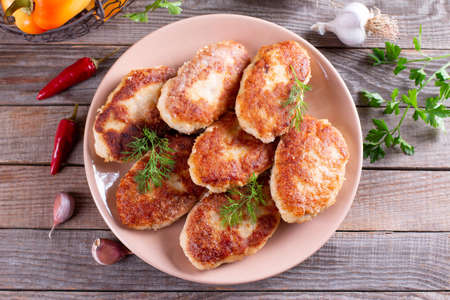 Fish cutlets on a plate on wooden table. Top view.の写真素材