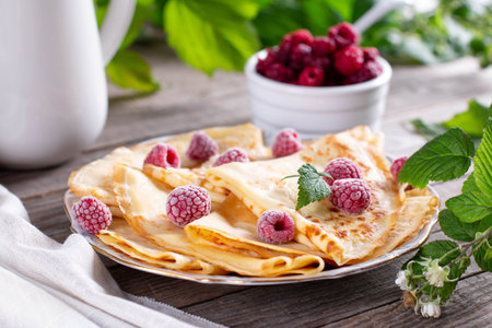 Plate with delicious thin pancakes and berries on wooden background. Maslenitsaの写真素材