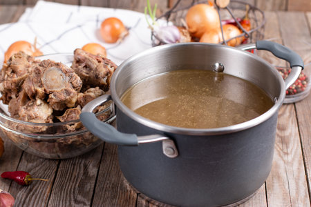 Bone Broth Bouillon in Metal saucepan on the table, paleo dietの写真素材