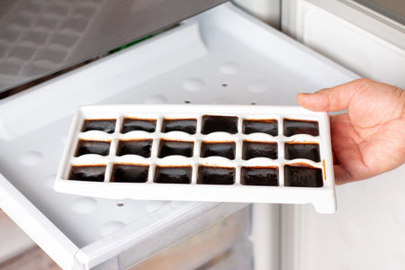 Ice cube tray with frozen coffee in the freezer. Cocktail ingredient.の写真素材