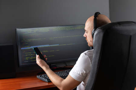 Young Professional programmer working at developing programming and website working in a software develop at home, writing codes and typing data code, Programming with HTML, PHP and javascript.の写真素材