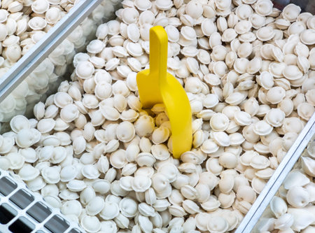 Frozen dumplings sold by weight in a refrigerator container on a store counter. Frozen food salesの写真素材