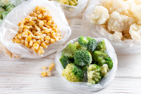 Mix of frozen vegetables in a bag on white table. Horizontal orientation.