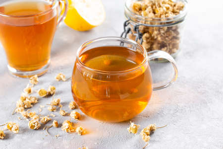 Chamomile tea on table, transparent cup with warm aromatic drink, relaxation and detoxの写真素材
