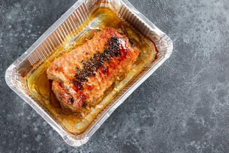 Baked roulade of minced meat stuffed with mushrooms on a stone background, flatlay, copy space