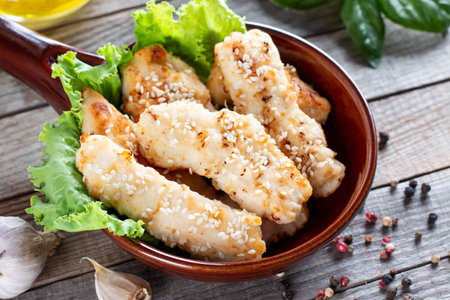 Crispy deep fried chicken strips with sesame seeds on wooden rustic backgroundの写真素材