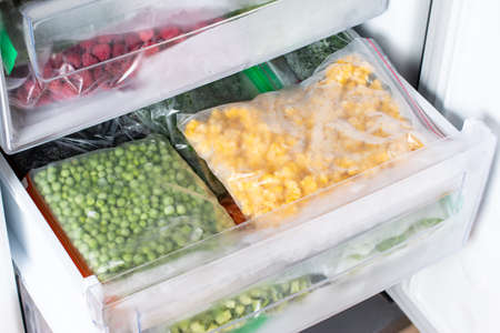 Plastic bags with different frozen vegetables in refrigerator. Food storageの写真素材