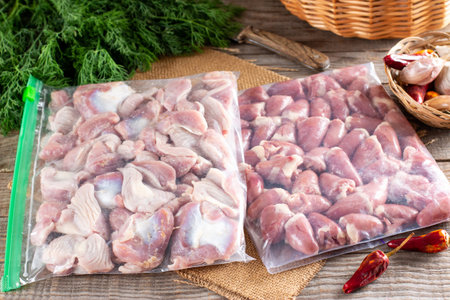 Frozen offal, liver, heart, stomachs in a plastic bag on a wooden table. Frozen products. Frozen...