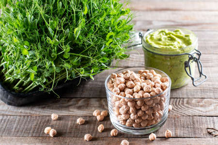 Chickpeas sprouts, dry chickpeas and green hummus on a table. Healthy organic food grown at home. Home planting.の写真素材