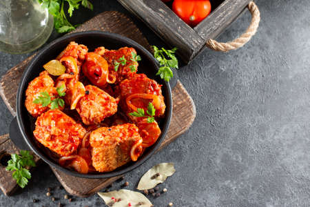 Fish in tomato sauce with lemon and parsley in a frying pan. Horizontal view from above, with copy spaceの写真素材