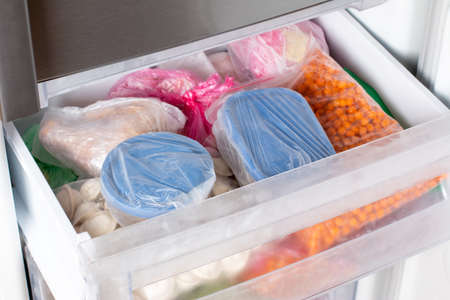Frozen food in the freezer. Frozen vegetables, soup, ready meals in the freezerの写真素材