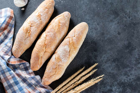 Fresh French Baguette Bread on dark background. Homemade french Baguette loafs, top view, copy space.の写真素材