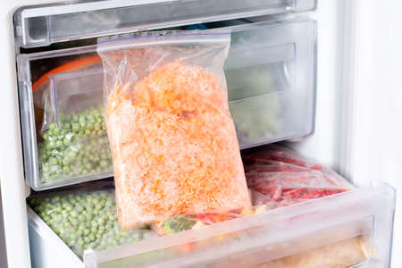 Frozen grated carrots in a bag in the freezer. frozen foodの写真素材