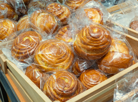 Freshly baked crispy bread buns on a counter or shelf in a store, close-up. Bakery products are sold...