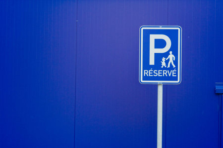 A blue reserved parking sign with white lettering, against a blue background.の写真素材