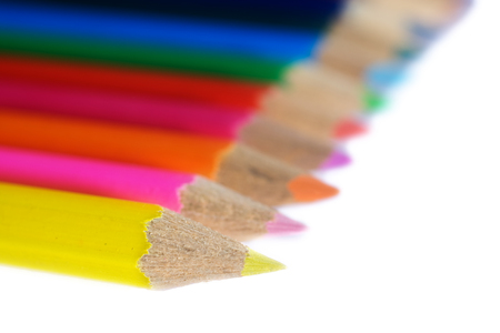 A closeup of the sharpened tips of wooden colored pencils with a narrow depth of field and the focus on the first pencil. の写真素材